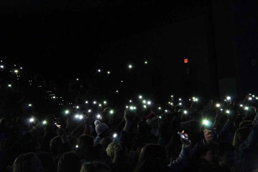 Students encourage performers with their flashlights.

